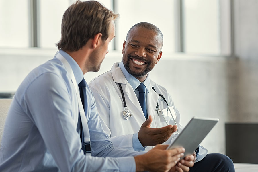Male audiologist reviewing results with a marketing expert