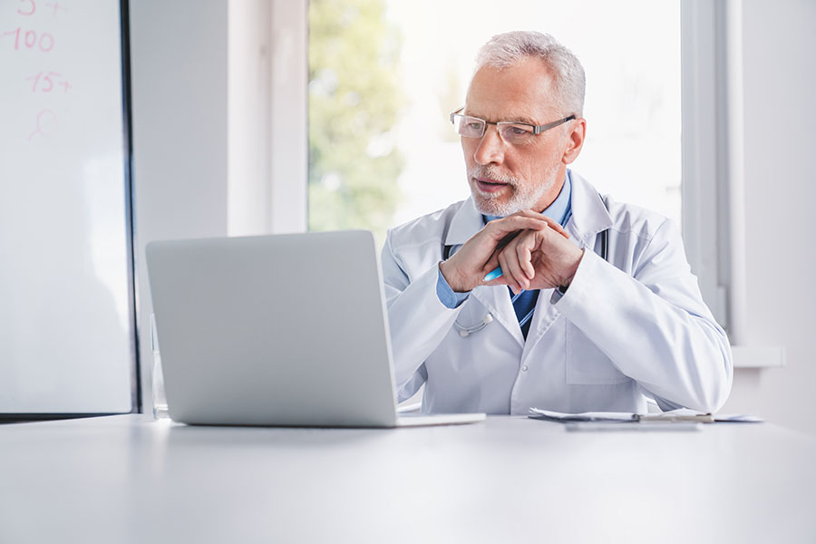 Otolaryngologist viewing practice growth results on a laptop