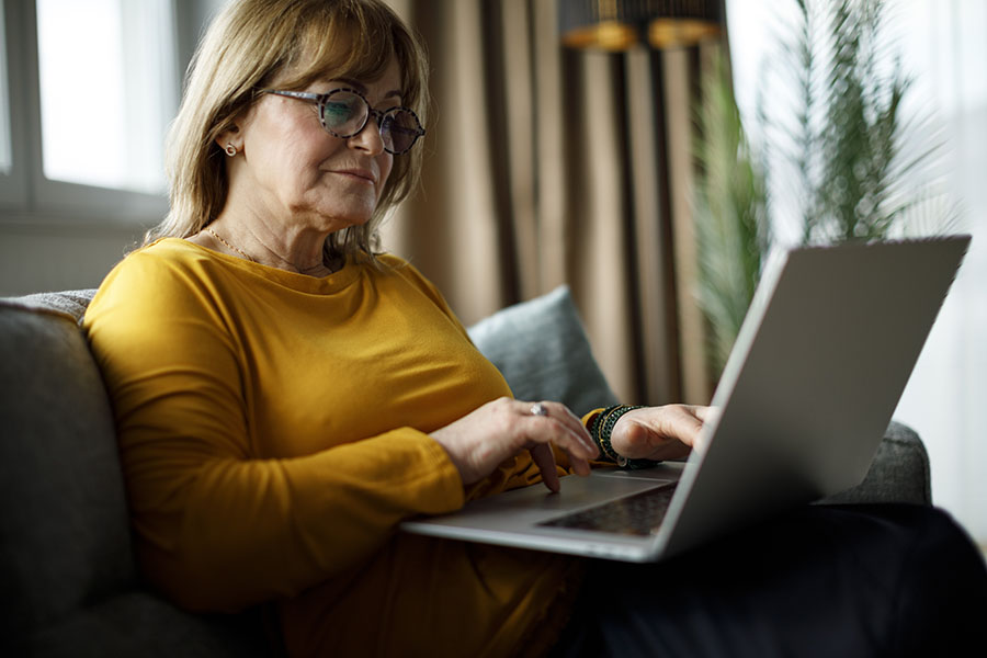 Woman on a laptop reading emails about new hearing technology