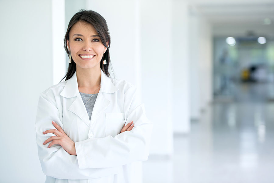 Woman audiologist smiling with arms crossed in a hearing aid office